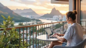 Digital nomad working on a laptop from a balcony overlooking a scenic long-term rental location